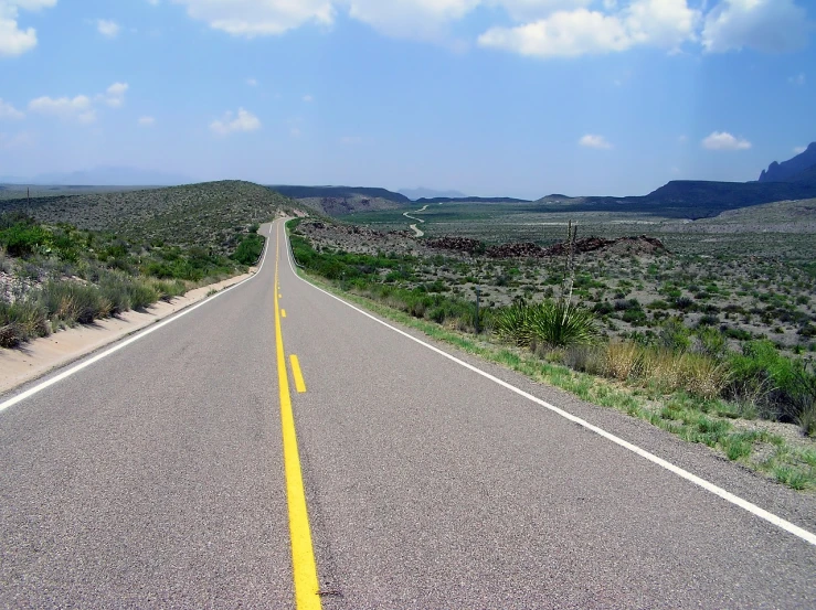 a road in the middle of a desert with mountains in the background, a picture, by Dennis Ashbaugh, flickr, realism, oklahoma, wide greenways, topdown, corduroy road