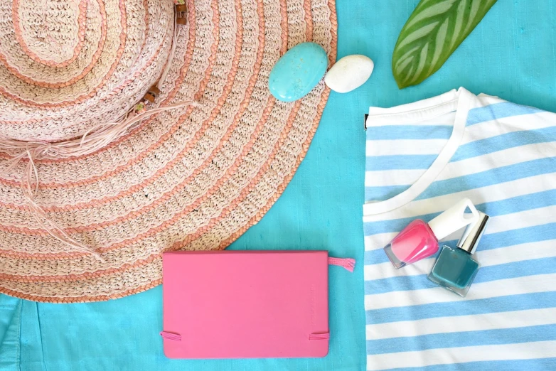 a straw hat sitting on top of a blue table, inspired by Giovanni Bellini, pink clothes, flatlay, turquoise palette, products shot