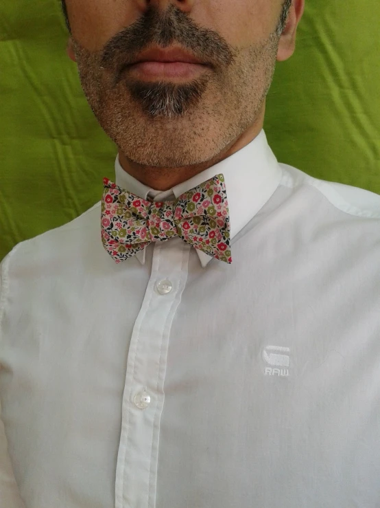 a close up of a man wearing a bow tie, inspired by Charles Harold Davis, neo-dada, floral!, very very happy!, view from front, uploaded