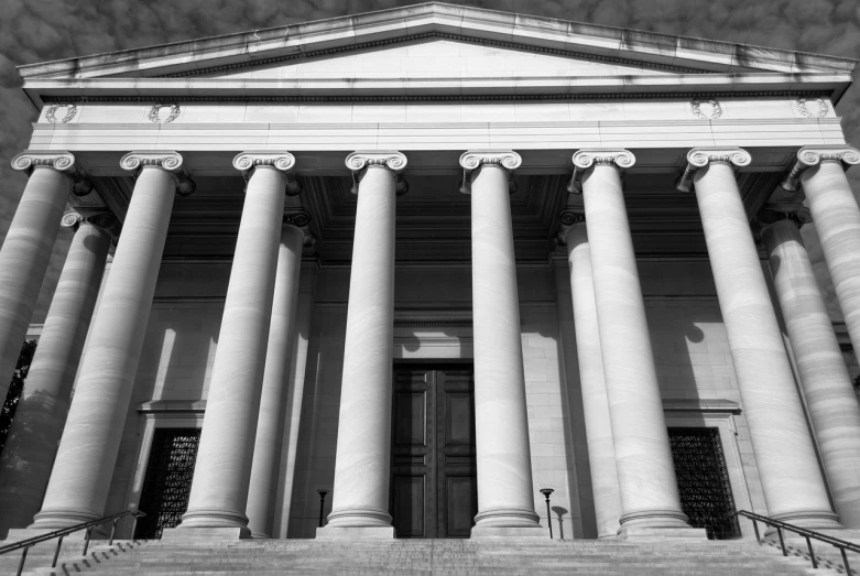 a black and white photo of a building with columns, a black and white photo, flickr, defense attorney, museum background, national gallery, private academy entrance