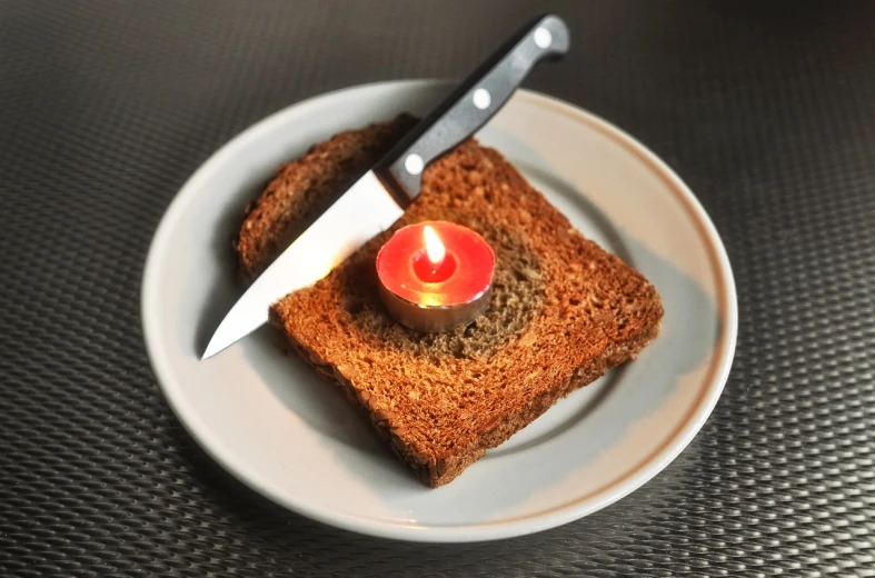a knife sitting on top of a piece of bread, by Edward Avedisian, minimalism, candle volumetric, toast, koyaanisqatsi, photo - manipulation