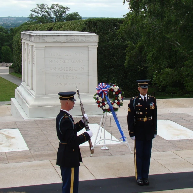 two men in military uniforms stand in front of a memorial, by Susan Heidi, flickr, performing to dead soldiers, tomb, above side view, united states