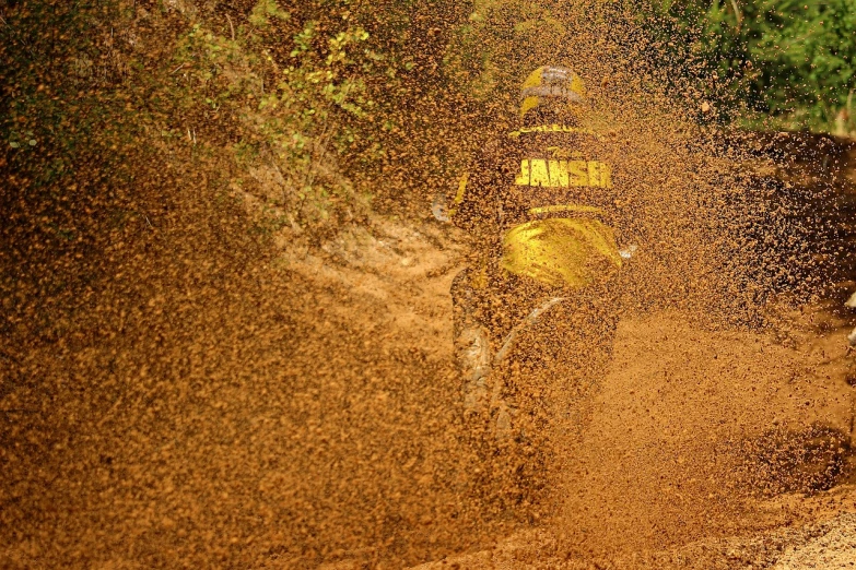 a person riding a dirt bike in the mud, by Dietmar Damerau, flickr, process art, yellow mist, rally driving photo, rain!!!!, full of sand and glitter
