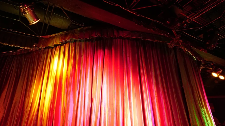 a stage with a colorful curtain and lights, by Edward Corbett, romanticism, phone photo, dramatic reddish light, lightshafts, img _ 9 7 5. raw