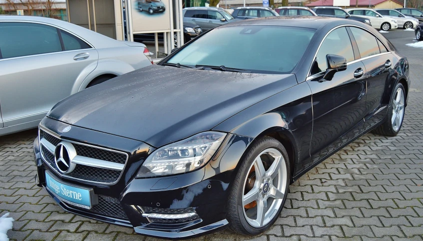 a black mercedes parked in front of a gas station, by Thomas Häfner, pixabay, with a sleek spoiler, front face asymmetrical, in 2 0 1 2, rotated left right front back