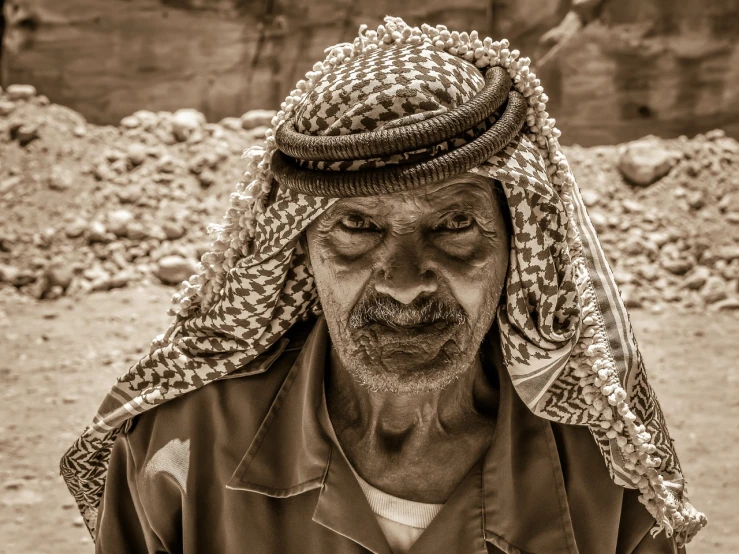 a black and white photo of a man wearing a headscarf, a black and white photo, by Ibram Lassaw, pixabay contest winner, dau-al-set, sepia colors, he is a mad old man, king of the desert, stone face