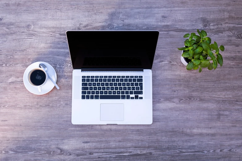 a laptop computer sitting on top of a wooden table, by Romain brook, pexels, morning coffee, clean and pristine design, [ overhead view of a table ]!!, glossy surface