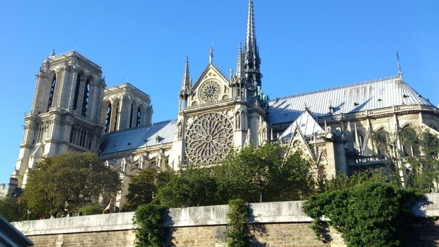 a very tall cathedral with a clock on it's side, a picture, flickr, parisian buildings, glorious sunlight, buttresses, from afar