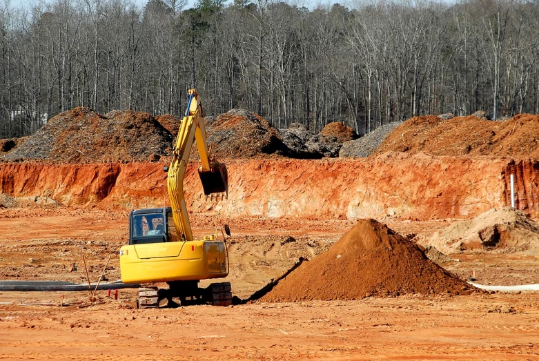 a yellow excavator sitting on top of a pile of dirt, a photo, by Douglas Shuler, pixabay, alabama, red shell. dirt track, deep sinkhole, -640