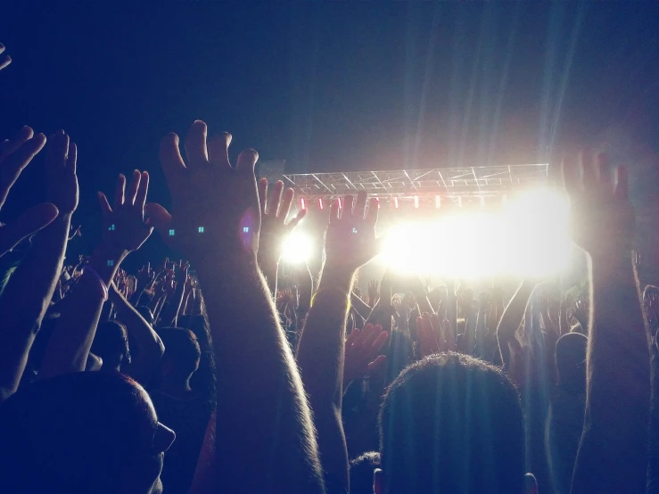 a crowd of people at a concert with their hands in the air, a picture, blog-photo, bokehlicious, backlighted, people