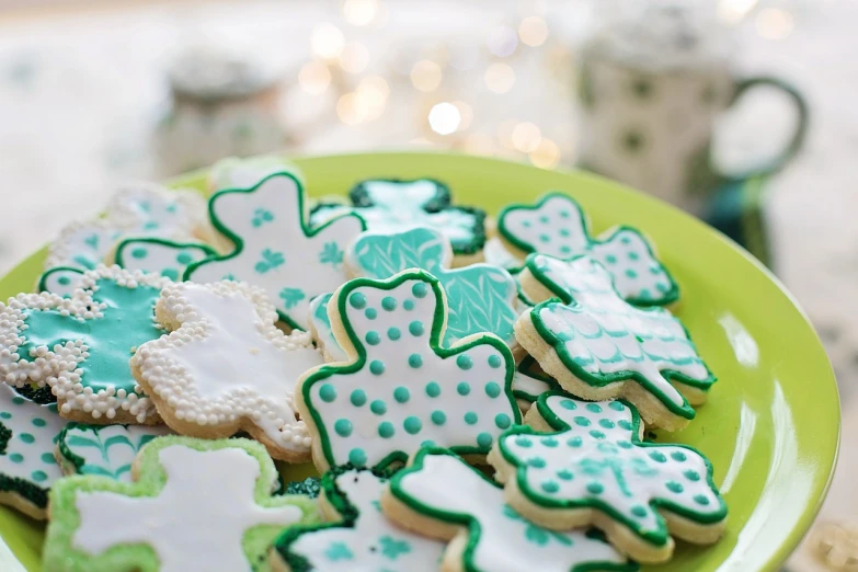 a plate of decorated cookies on a table, a picture, inspired by Dóra Keresztes, pexels, four leaf clover, green robes, dotting, 4 0 9 6