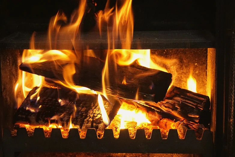 a close up of a fire burning in a fireplace, a picture, by Robbie Trevino, pixabay, wikimedia commons, grill, warm wood, bottom angle