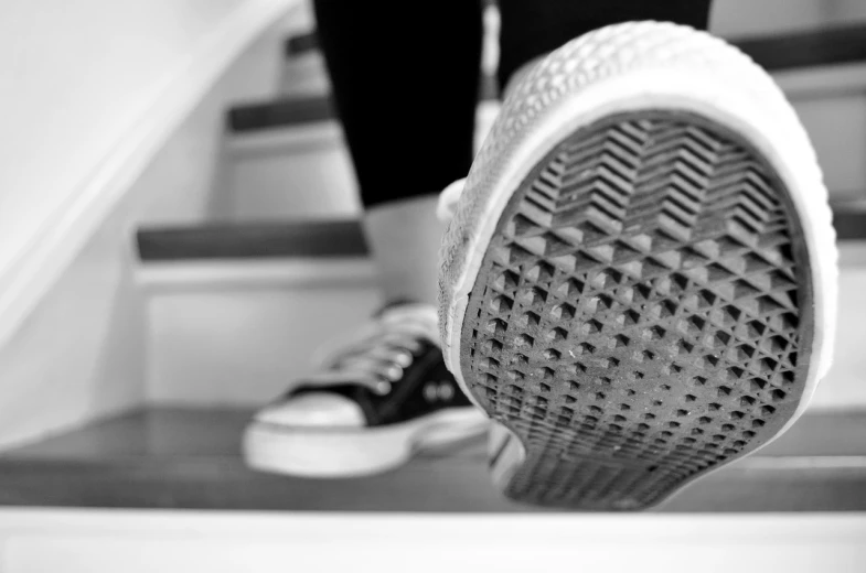 a person walking up a flight of stairs, a black and white photo, rubber waffle outsole, close up portrait photo, at home, low angle photo