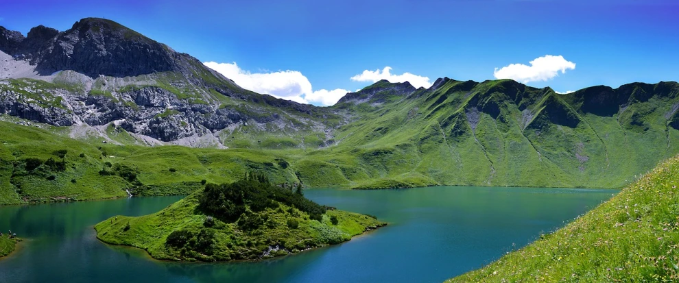 a large body of water surrounded by mountains, by Werner Andermatt, flickr, renaissance, green hills, heaven on earth, lake blue, genevieve gauckler