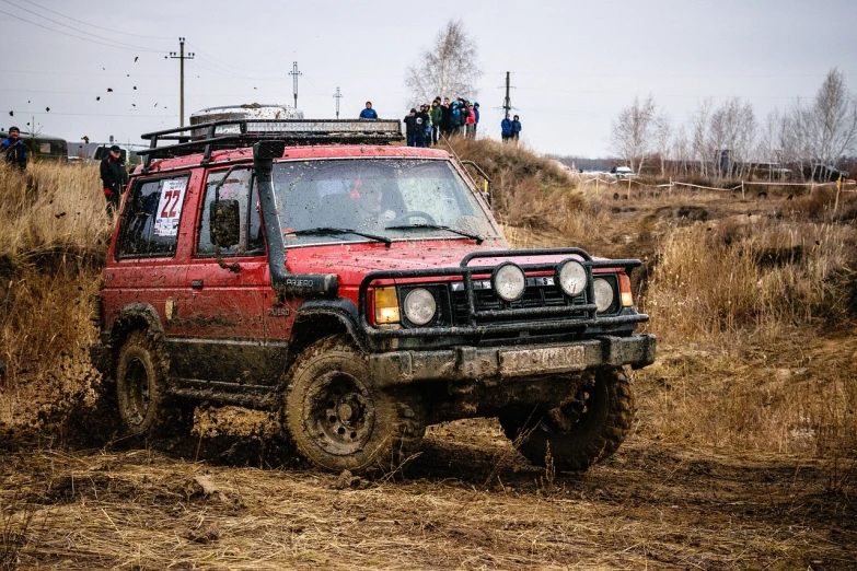 a red jeep driving through a muddy field, a portrait, by Aleksander Gierymski, shutterstock, in a race competition, taken on a 1990s camera, kama russian electrocar, indoor shot