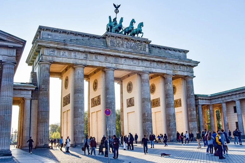 a group of people that are standing in front of a building, pexels, berlin secession, an archway, untethered stelae, german chancellor, wikimedia