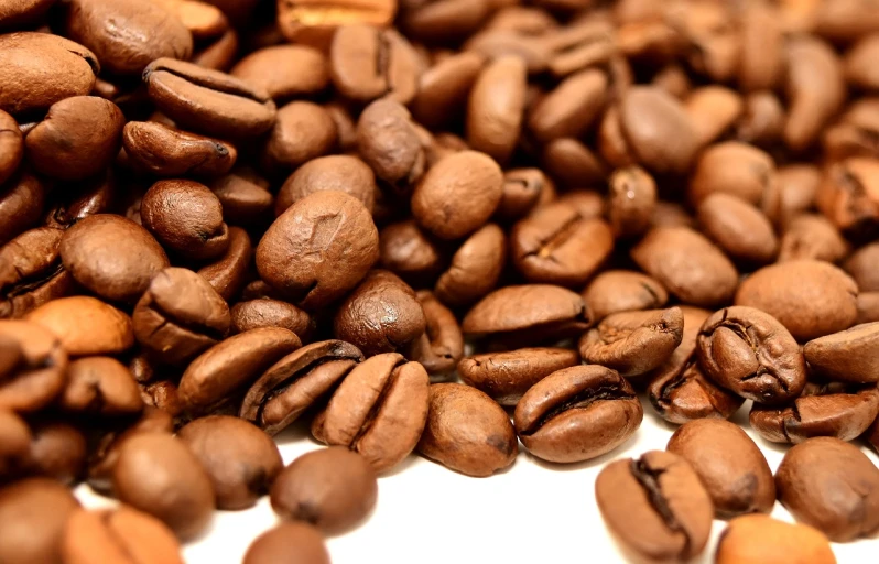 a pile of coffee beans sitting on top of a table, figuration libre, close-up product photo