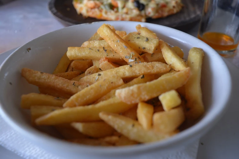 a bowl of french fries sitting on a table, figuration libre, traditional corsican, food photo