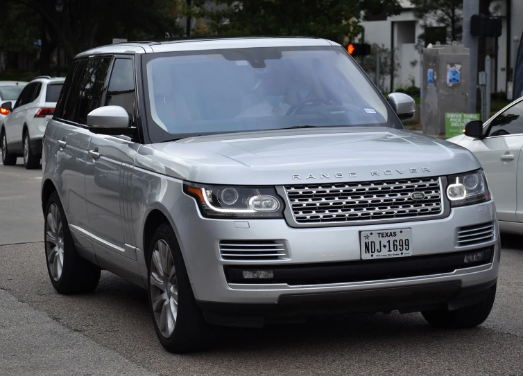 a silver land rover parked on the side of the road, j - lo, ridiculously handsome, royality, 2 0 1 4