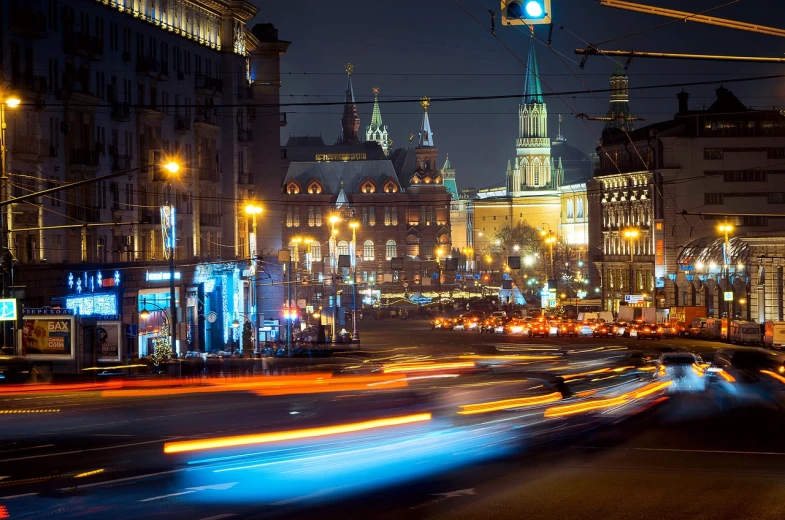 a city street filled with lots of traffic at night, a stock photo, by Alexey Venetsianov, shutterstock, socialist realism, majestic spires, photo taken with sony a7r, moscow kremlin, panning shot