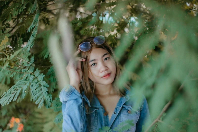 a woman in a denim shirt and sunglasses posing for a picture, a picture, by Tan Ting-pho, unsplash, greenery, portrait of cute girl, 🤤 girl portrait, hiding