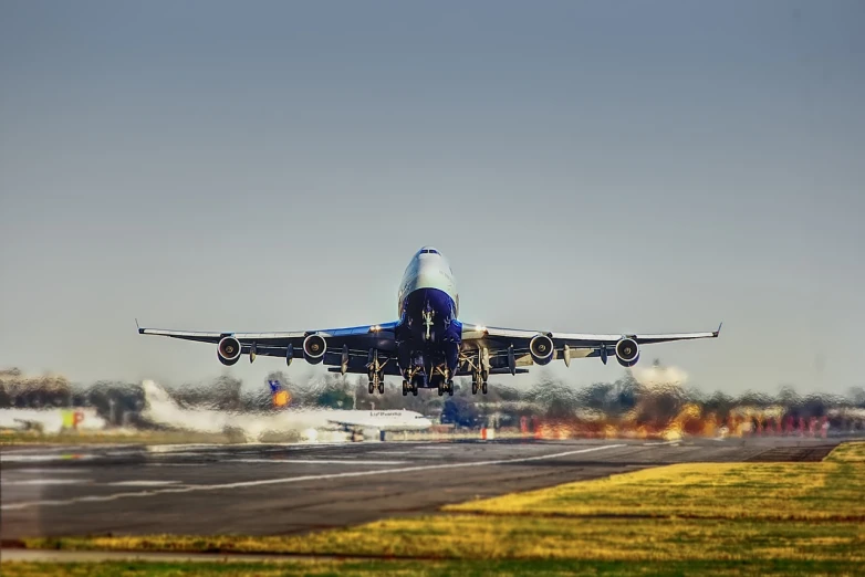 a large jetliner taking off from an airport runway, a tilt shift photo, marvelous expression, large blue engines, travelling through misty planes, low angle photo