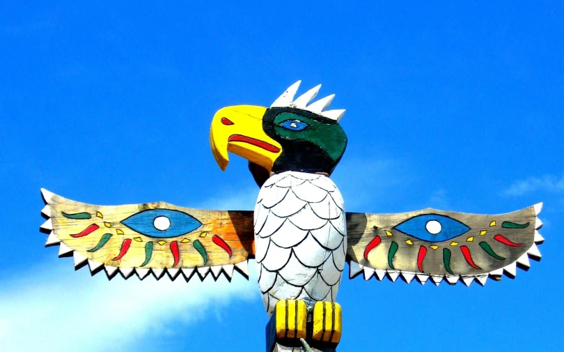 a bird that is sitting on top of a pole, inspired by George Catlin, flickr, folk art, second eagle head, mayan god, tourist photo, hziulquoigmnzhah