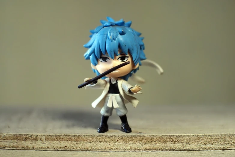 a close up of a figurine of a person with a sword, a picture, flickr, shin hanga, messy blue hair, katekyo hitman reborn, mini figure, tiny sticks