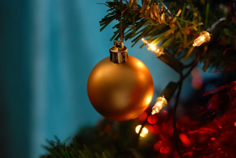 a gold ornament hanging from a christmas tree, a picture, by Maksimilijan Vanka, shutterstock, 2 4 mm iso 8 0 0 color, key hole on blue ball, with photorealistic lighting, bangalore