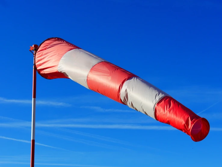 a large red and white kite flying in the sky, by Jan Rustem, flickr, big long cloth on the wind, harbor, sky blue and white color scheme, cone