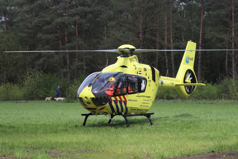 a yellow helicopter sitting on top of a lush green field, a photo, by Petr Brandl, ambulance, !female, k9, unrea 5