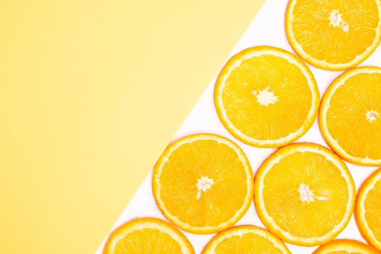 a pile of sliced oranges sitting on top of a table, by Joseph-Marie Vien, trending on unsplash, postminimalism, bright yellow color scheme, 🪔 🎨;🌞🌄, half image, flatlay