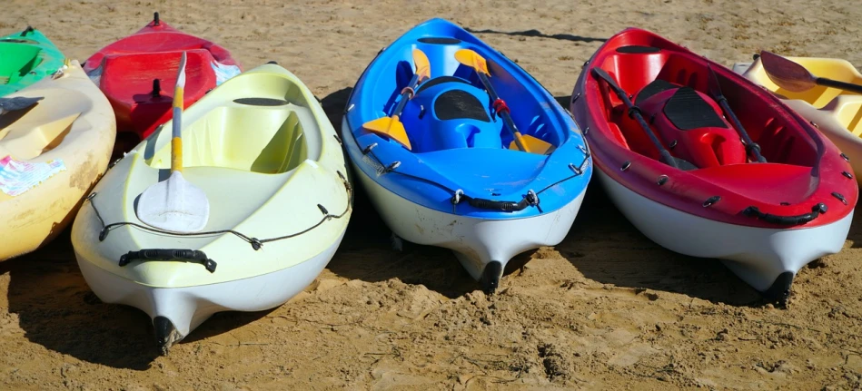 a group of kayaks sitting on top of a sandy beach, a picture, shutterstock, plasticien, glossy surface, 3 colors, hull, sand color