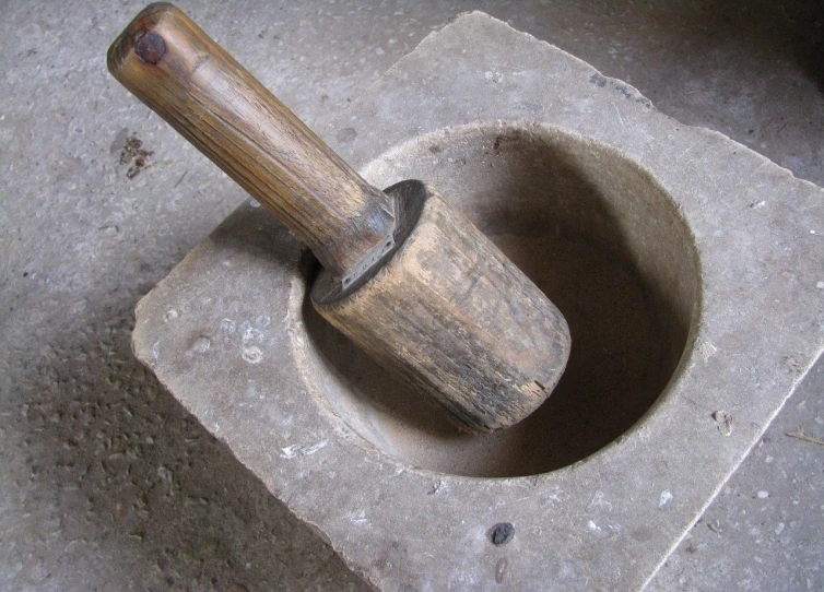a mortar with a wooden stick sticking out of it, flickr, mingei, pestle, made of concrete, st cirq lapopie, interior view