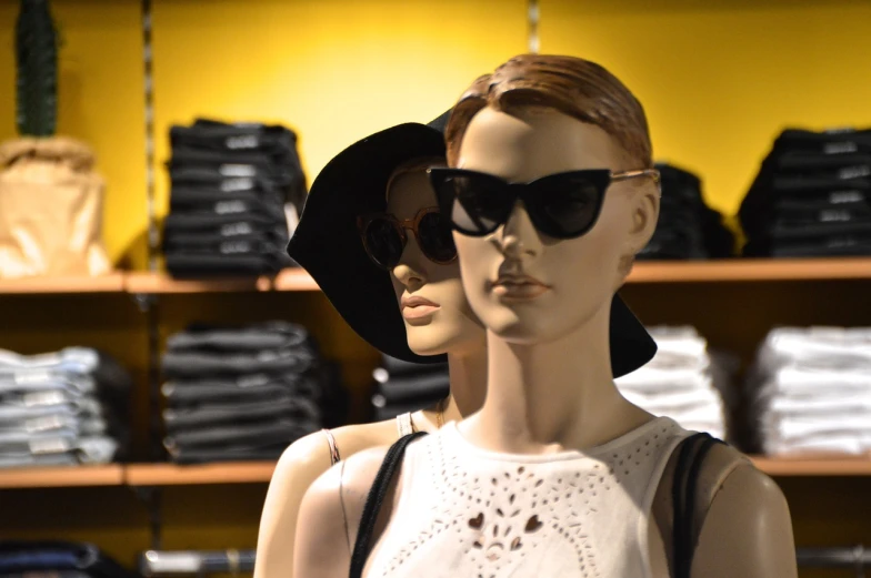 a couple of mannequins standing next to each other, a photo, by Bernie D’Andrea, sunglasses on, loosely cropped, female-focus, yellow and black color scheme