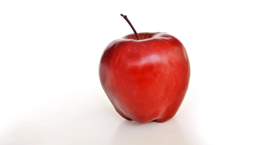 a red apple sitting on top of a white surface, a picture, from wikipedia, 5 feet away, a broad shouldered, a tall