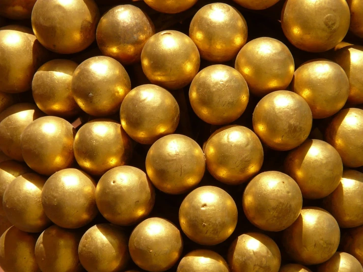 a pile of golden eggs sitting on top of each other, by Róbert Berény, bullet tracers, cannonballs, closeup photo, brass and steam technology
