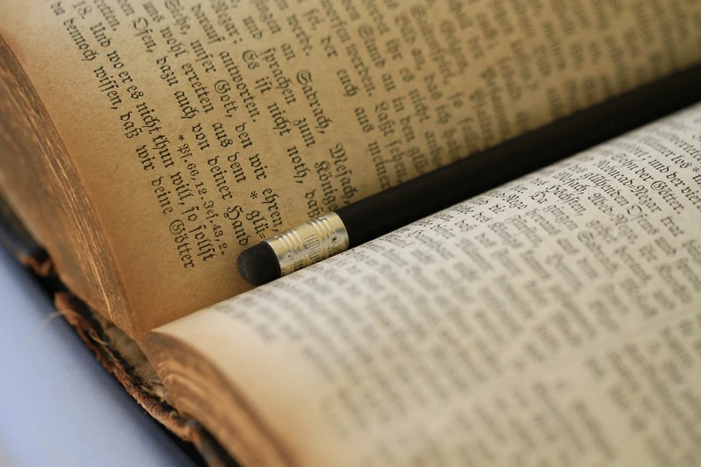 an open book with a pencil sticking out of it, by Edward Clark, pexels, old testament, a close up shot, modeled, marker”