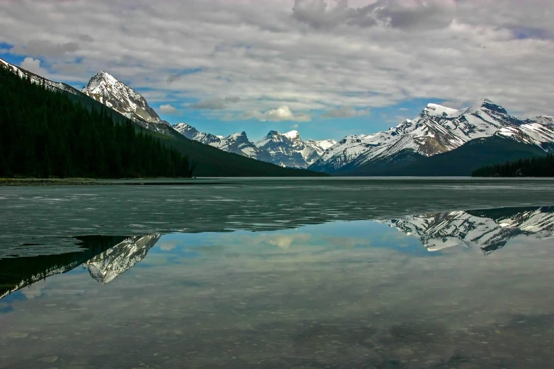 a large body of water with mountains in the background, a picture, by Jim Nelson, flickr, banff national park, mirror and glass surfaces, icy mountains, symmetry!! full shot!!