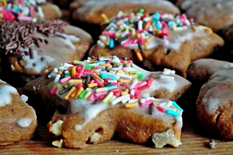 a table topped with lots of doughnuts covered in frosting and sprinkles, by Magdalene Bärens, hurufiyya, gingerbread people, seventies, fitness, chunky!!!