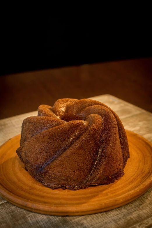 a bundt cake sitting on top of a wooden plate, by Adam Manyoki, alabama, award winning dark, chozo, full round face!