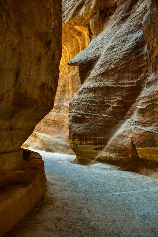 a narrow slot in the side of a canyon, a picture, by Thomas Häfner, shutterstock, empty bathhouse hidden in a cave, jordan, very beautiful masterpiece, falling sand inside