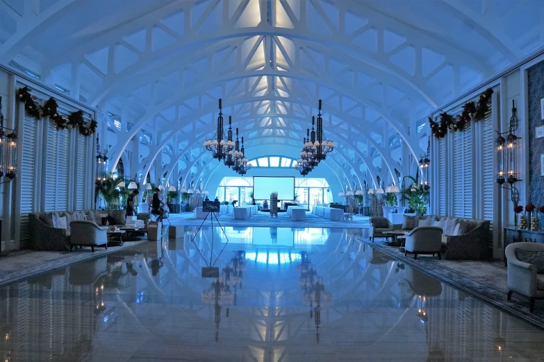 a living room filled with furniture and a chandelier, inside futuristic hangar, atlantis, white sweeping arches, cuba