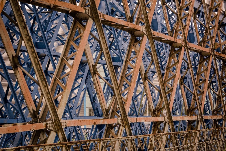 a close up of a metal structure with a clock on it, unsplash, precisionism, strong blue and orange colors, howrah bridge, scaffolding collapsing, wood bridges