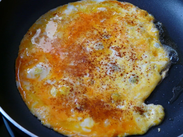 an omelet is cooking in a frying pan, inspired by Géza Dósa, hurufiyya, egg yolk, caramel, mac, buffalo