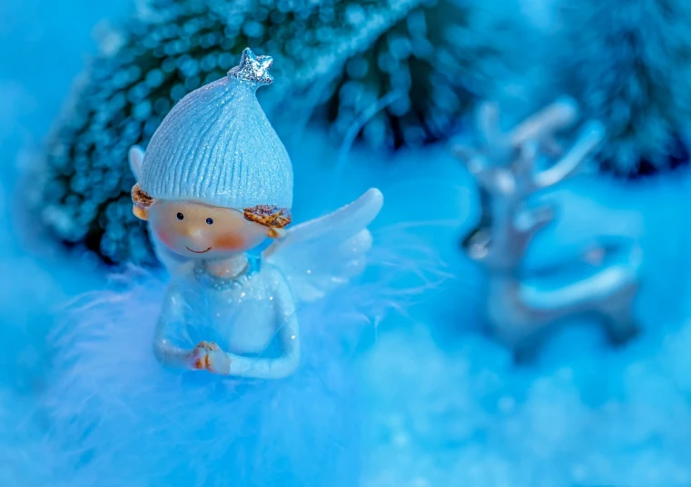 a close up of a figurine of an angel, a macro photograph, trending on pixabay, blue fur, shining and happy atmosphere, wearing festive clothing, sweet and innocent