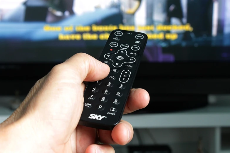 a hand holding a remote control in front of a tv, skydome, skary, beginner, high-details