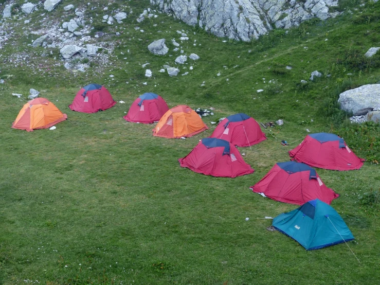 a group of tents sitting on top of a lush green hillside, by Muggur, flickr, multi colour, closeup - view, pretty face!!, rock star