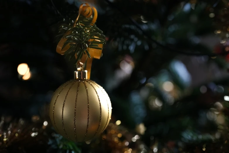 a close up of a christmas ornament on a tree, a picture, by Maksimilijan Vanka, pixabay, shades of gold display naturally, 4 k cinematic still, stock photo, on a dark background