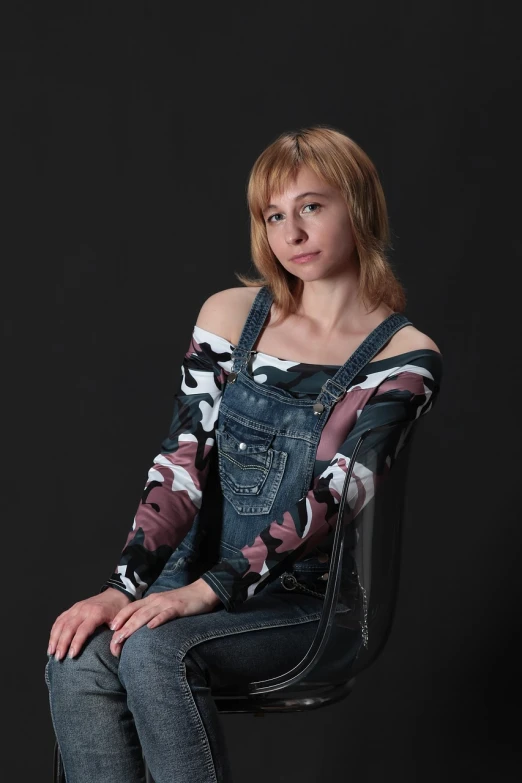 a beautiful young woman sitting on top of a chair, a portrait, by Serhii Vasylkivsky, flickr, wearing camo, wearing blue jean overalls, sophia lillis, in a photo studio